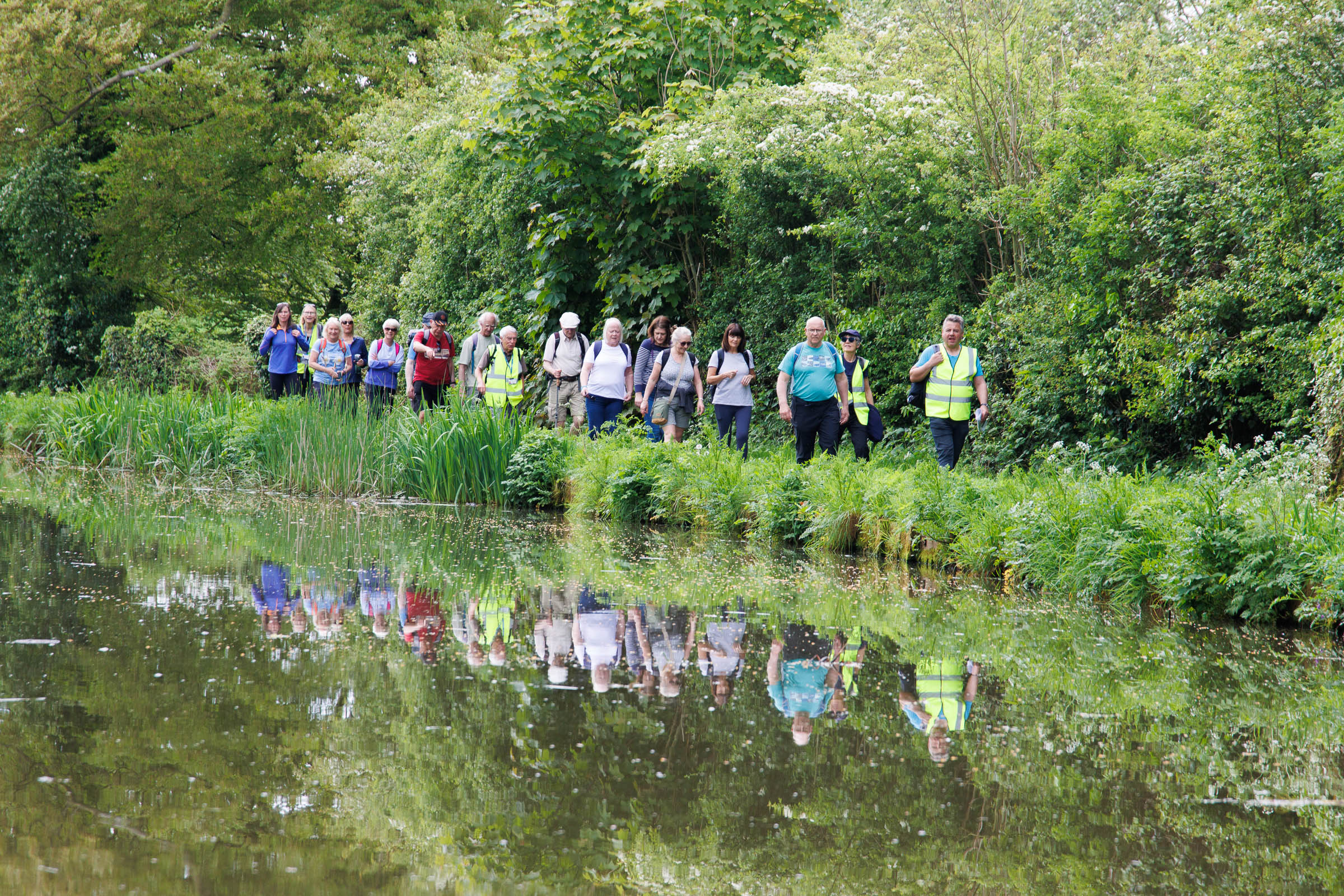 Group of people walking in a line by edge of the River Wyre