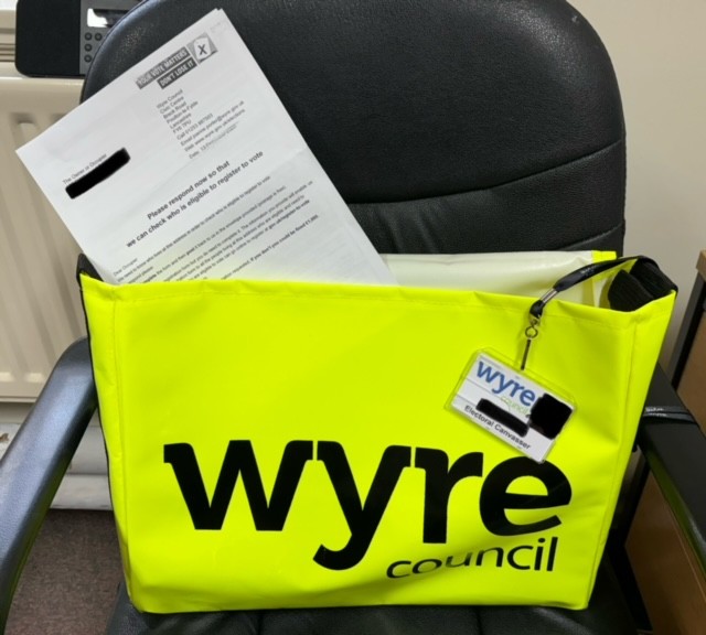 Document coming out of a bright yellow Wyre Council post bag.