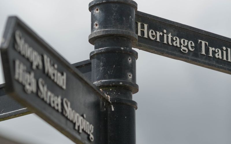 Iron sign in the middle of Garstang pointing to the Heritage trail and High Street Shopping.